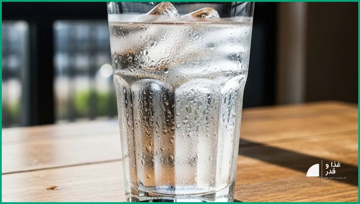 لیوان آب خنک روی میز چوبی